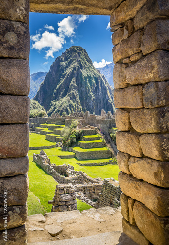 The Inca ruins of Machu Picchu, UNESCO World Heritage Site through the frame of stone wall