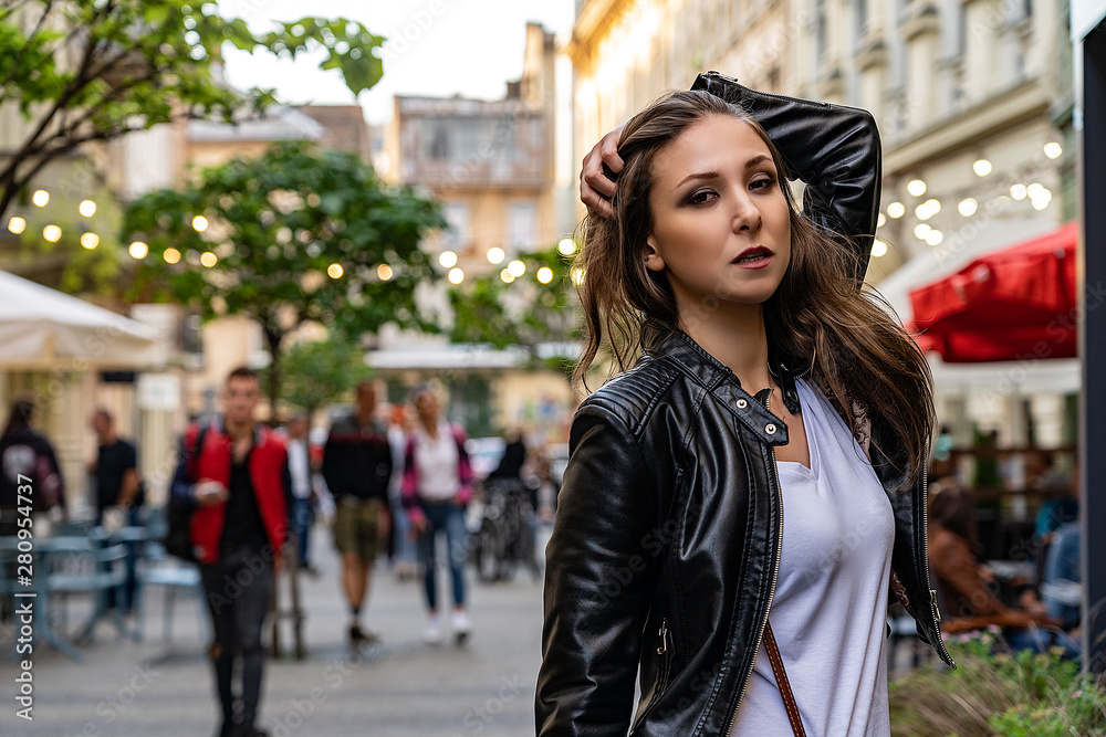 Young beautiful girl in black leather jacket on the street of city. Street fashion photo shoot with beautiful female model