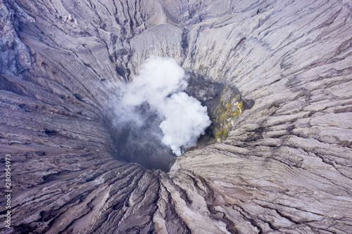 Crater of mount Bromo with volcanic smoke