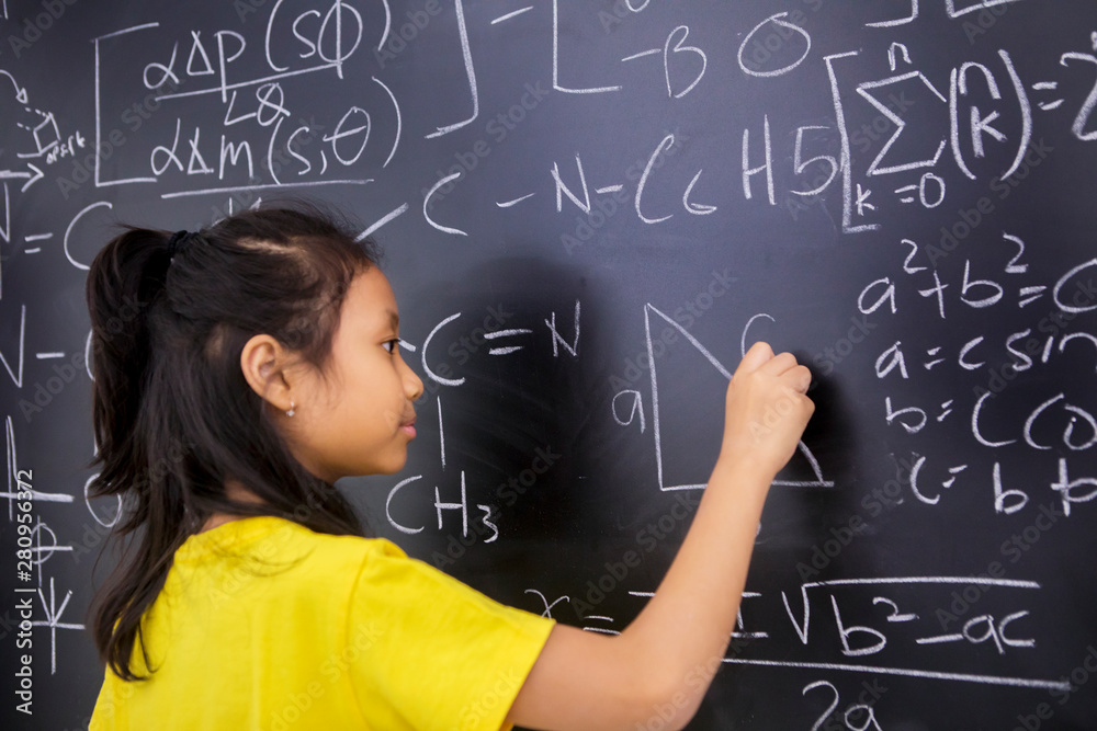 Female student writes mathematics formula Female student writes mathematics formula