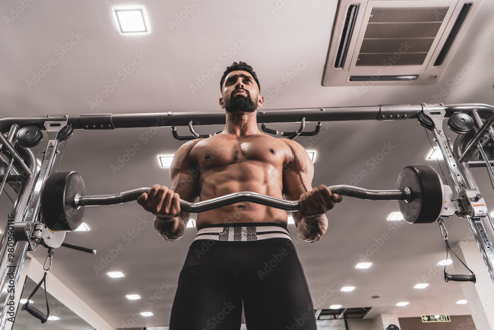Fototapeta premium Handsome Muscular Male Model With Perfect Body Doing Biceps Exercise