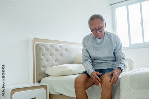 Senior man suffering from knee pain at home © Creativa Images