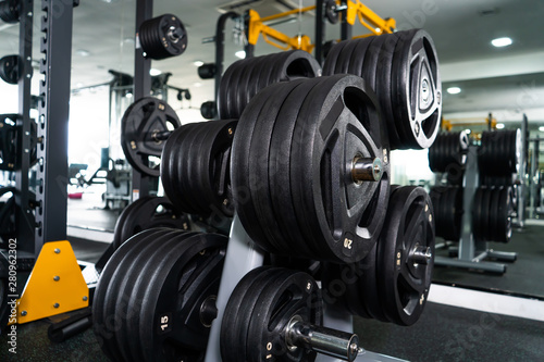 Modern light gym. Sports equipment in gym. Barbells of different weight on rack. © Gayan
