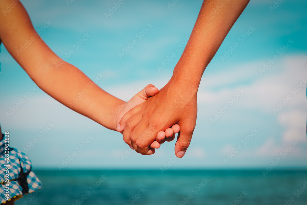 boy and girl holding hands at sea, frendship and care boy and girl holding hands at sea, frendship and care