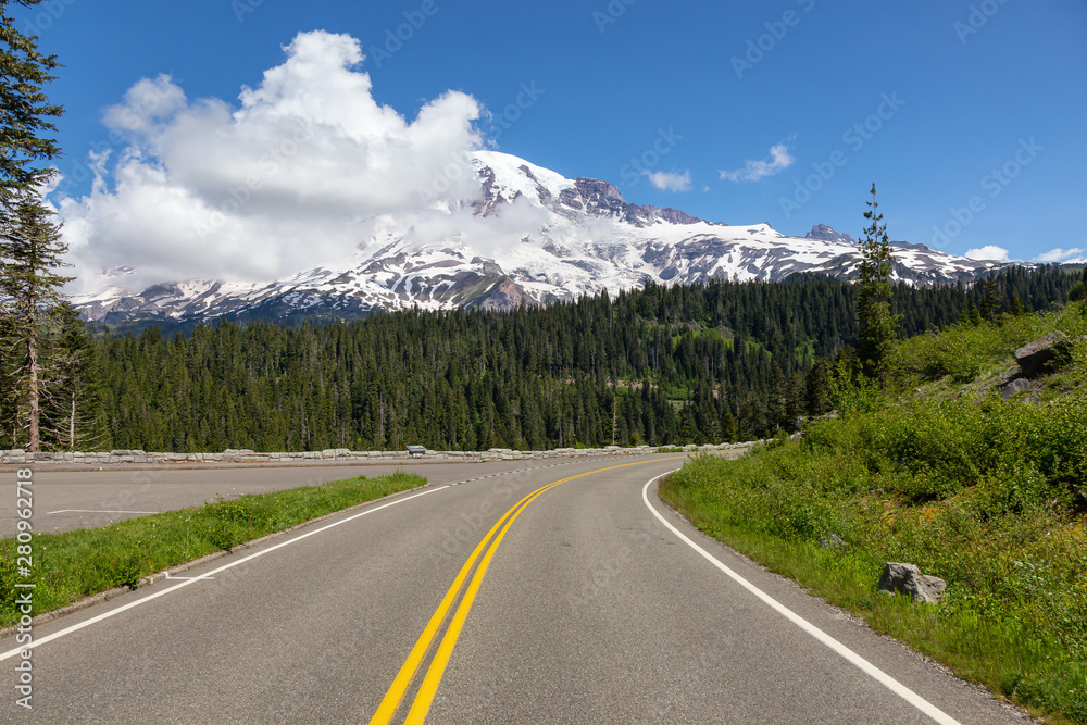 Fototapeta premium Beautiful view of a scenic road surrounded by the Mountain Landscape during a sunny summer day. Taken in Paradise, Mt Rainier National Park, Washington, United States of America.
