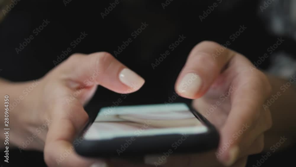 Close up of women's hands holding cell telephone text message or promotional content, hipster girl watching video retouch photo in subway Close up of women's hands holding cell telephone text message or promotional content, hipster girl watching video retouch photo in subway
