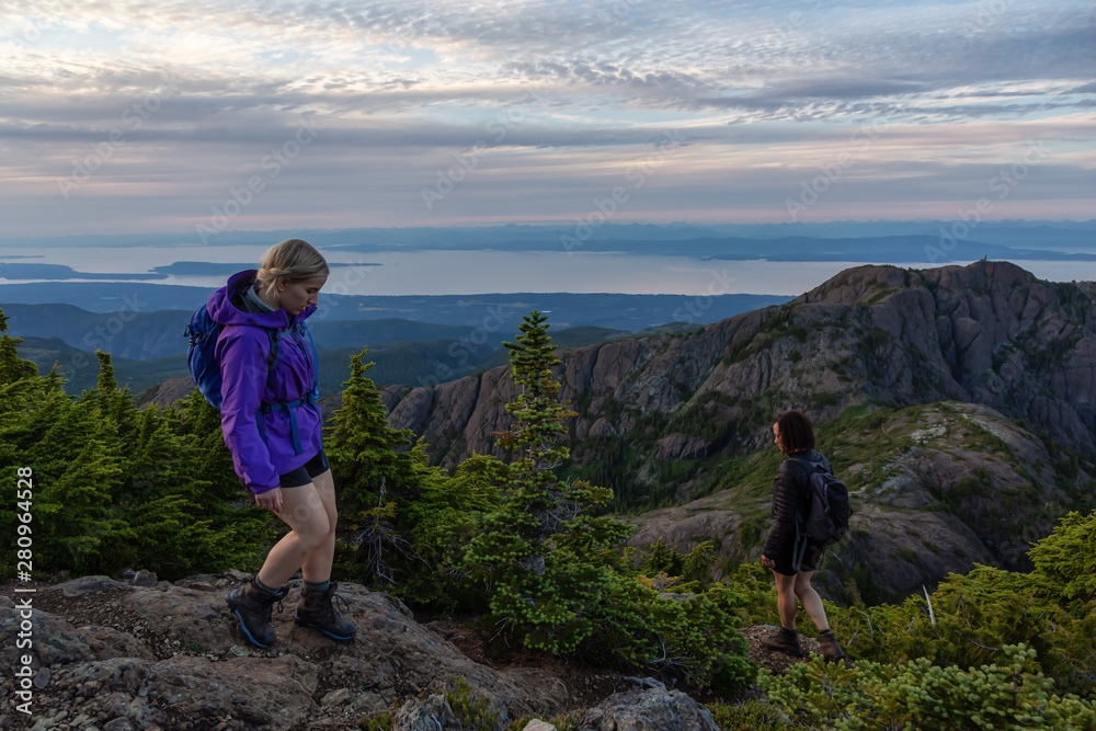 Adventurous girl hiking the beautiful trail in the Canadian Mountain Landscape during a vibrant summer sunset. Taken at Mt Arrowsmith, near Nanaimo, Vancouver Island, BC, Canada. Adventurous girl hiking the beautiful trail in the Canadian Mountain Landscape during a vibrant summer sunset. Taken at Mt Arrowsmith, near Nanaimo, Vancouver Island, BC, Canada.