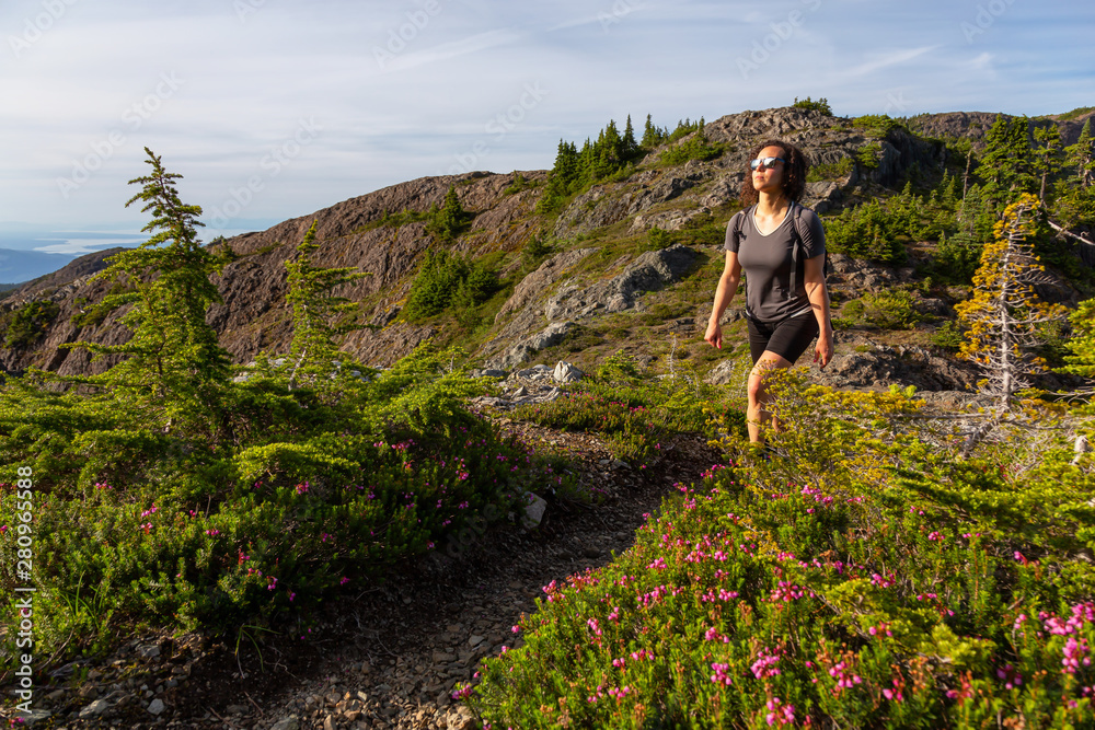 Adventurous girl hiking the beautiful trail in the Canadian Mountain Landscape during a vibrant summer evening. Taken at Mt Arrowsmith, near Nanaimo, Vancouver Island, BC, Canada.