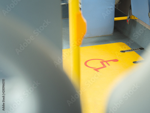 Close-up handicap logo in a bus. Priority seat for disabled people. Wheelchair accessible transportation concept.