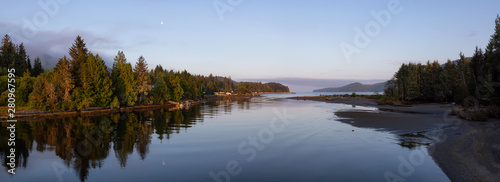 Fototapeta Naklejka Na Ścianę i Meble -  Beautiful Panoramic View of a river joining the ocean in a small town during a cloudy and sunny summer sunrise. Taken at Port Renfrew, Vancouver Island, BC, Canada.