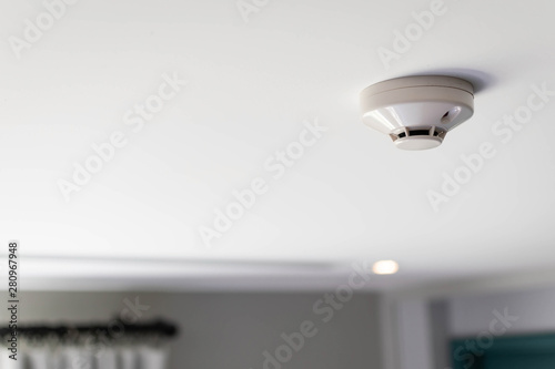Close up of a smoke detector  attached on the ceiling of the hotel room, copy space