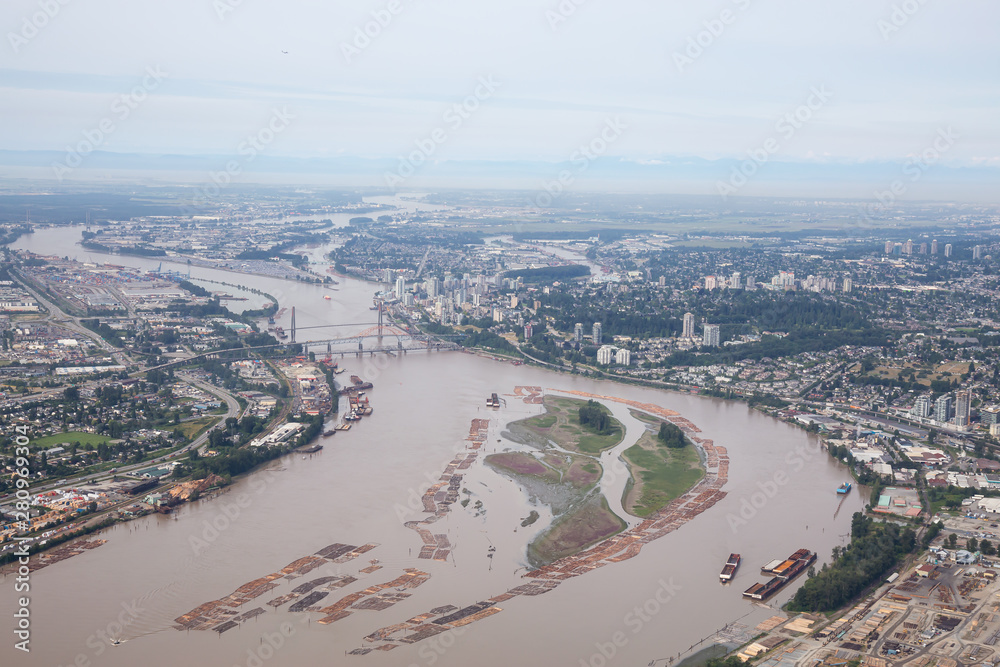 Aerial view of Industrial Sites in Fraser River during a misty summer day. Taken in New Westminster, Greater Vancouver, British Columbia, Canada.