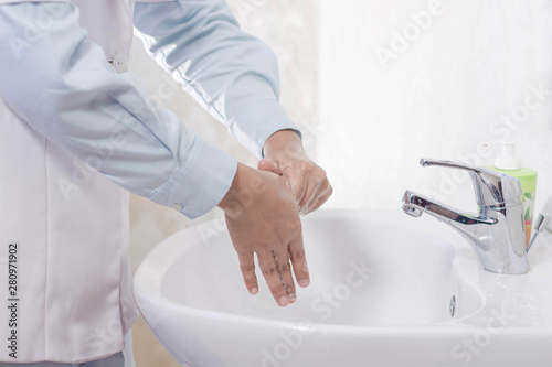 close up body part of female doctor hand washing in the sink with streaming water and soap foam