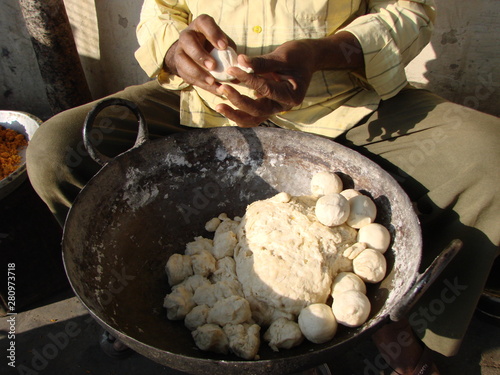 Indian man rolls dough balls samosa for breakfast