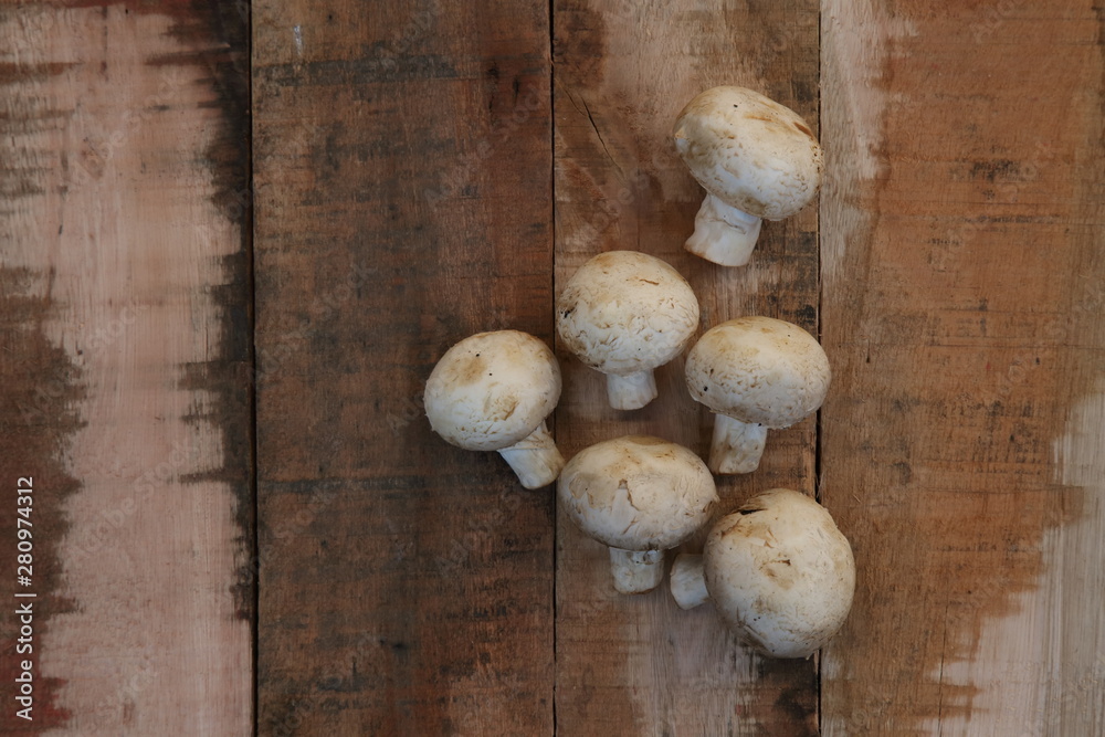 edible mushrooms campignon on rustic wooden background
