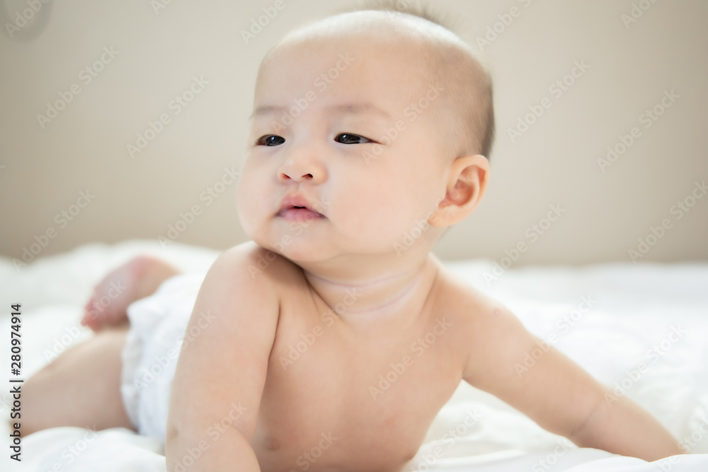 Asian baby happy in the room.Asian baby girl lying down on bed .