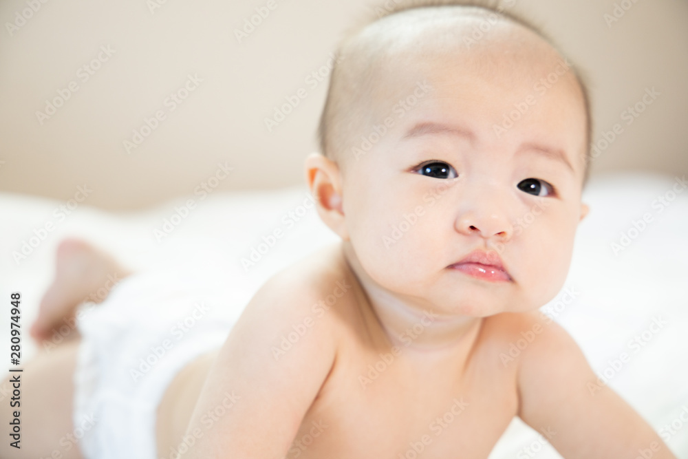 Asian baby happy in the room.Asian baby girl lying down on bed . Asian baby happy in the room.Asian baby girl lying down on bed .