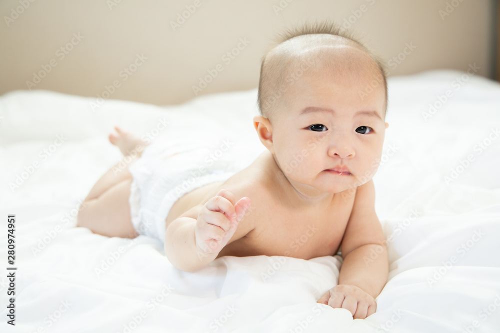 Asian baby happy in the room.Asian baby girl lying down on bed . Asian baby happy in the room.Asian baby girl lying down on bed .