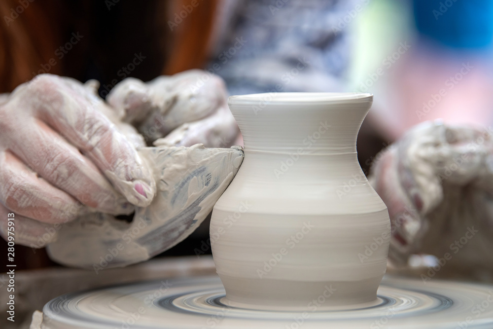 Potter makes pottery dishes on potter's wheel Potter makes pottery dishes on potter's wheel