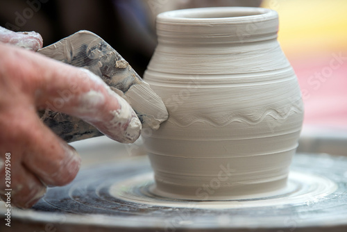 Potter makes pottery dishes on potter's wheel