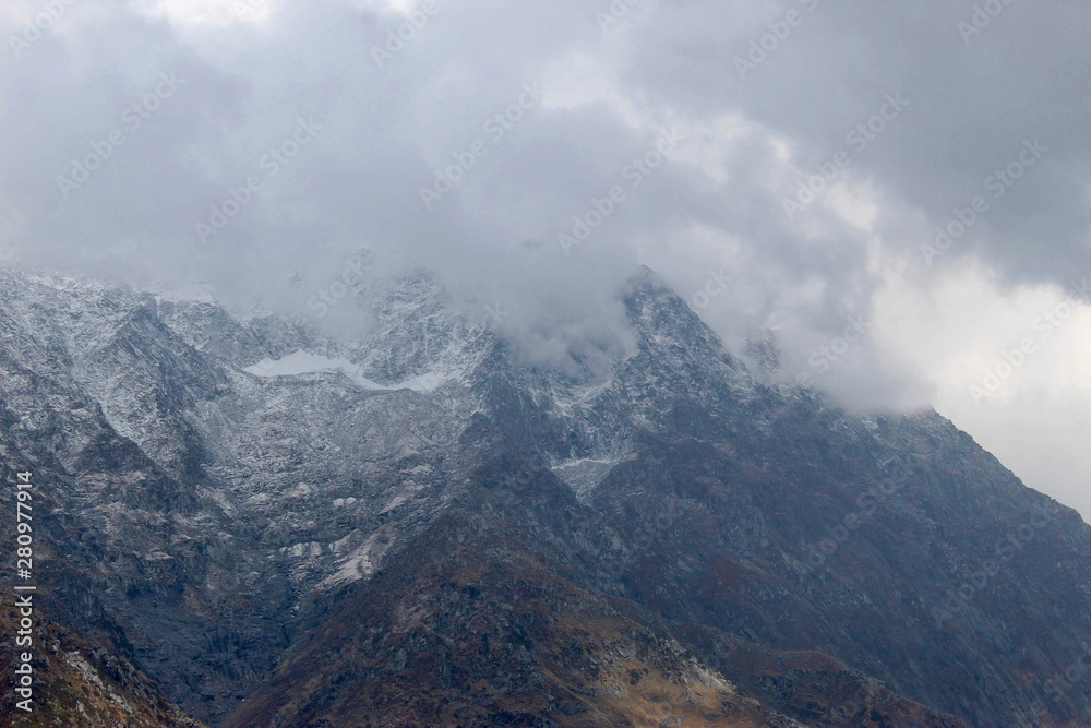 clouds over mountains covered with snow