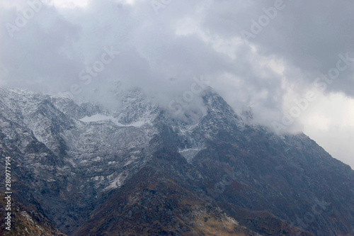 clouds over mountains covered with snow