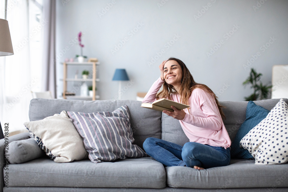 Beautiful young woman reading book at home. - obrazy, fototapety, plakaty 