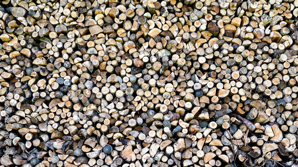 Background of dry chopped firewood logs in a pile. Preparation for the winter season, fossil fuels Background of dry chopped firewood logs in a pile. Preparation for the winter season, fossil fuels