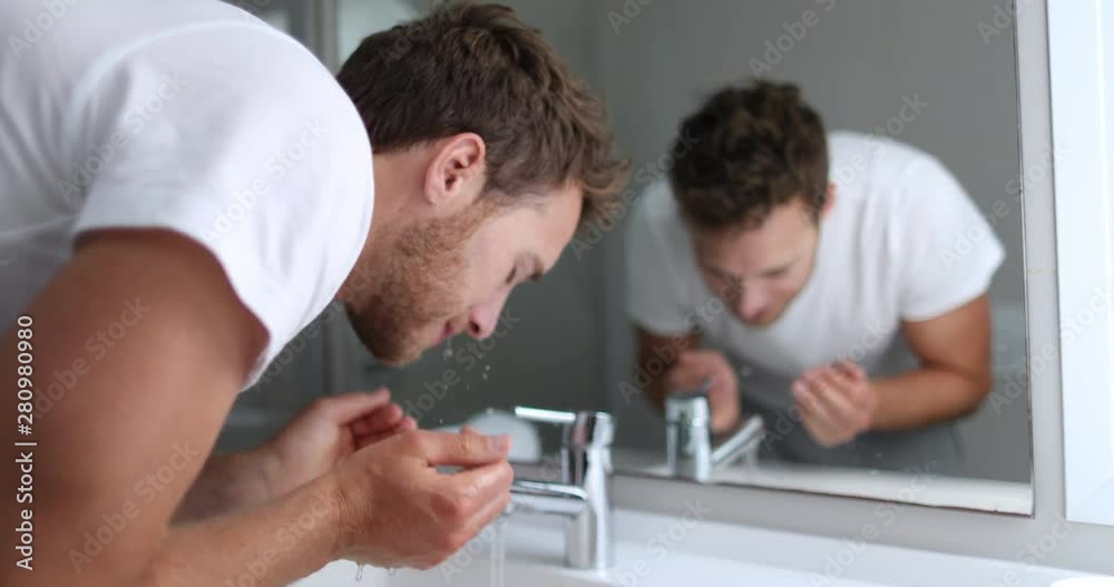 Man washing face rinsing soap from skin in sink under running cold water from faucet, Morning skincare routine. Male beauty skin care facial wash. Mask treatment. 4K (UHD) 59.94 FPS SLOW MOTION. Man washing face rinsing soap from skin in sink under running cold water from faucet, Morning skincare routine. Male beauty skin care facial wash. Mask treatment. 4K (UHD) 59.94 FPS SLOW MOTION.