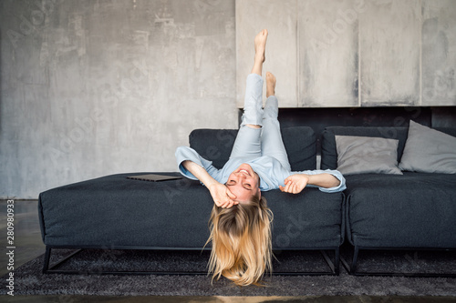Woman enjoying on a couch with head upside down.