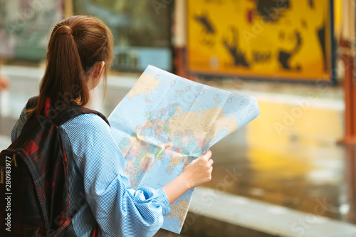 Shot of a young woman traveler or backpacker using map choose where to travel at train, Travel Concept