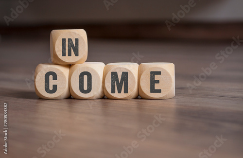 Cubes and dice with term Income on wooden background