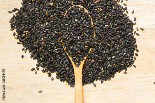 Black sesame in wooden spoon on wooden board ; Food background  photo