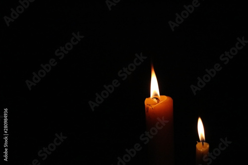 Soft-focused dramatic burning candle lights at night
