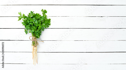 Parsley root on a white wooden background. Top view. Free space for your text. © Yaruniv-Studio