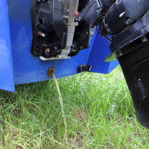 Drainage of bilge water through the drain scupper on transom motor boat with outboard motor