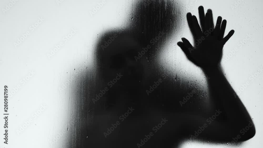 Male and female shadows making love behind rain drops window, intimacy passion