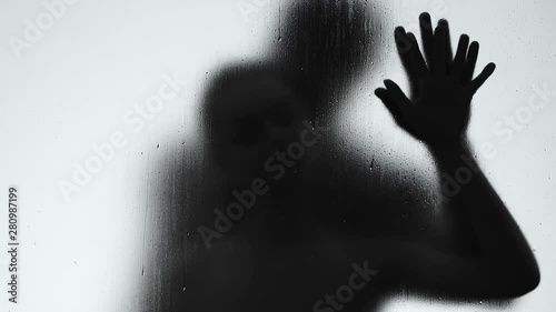 Male and female shadows making love behind rain drops window, intimacy passion
