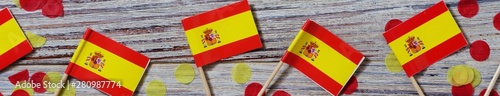 October 12. Independence day Spain concept of independence , patriotism and freedom. Mini paper flags with yellow red confetti on wooden background. banner