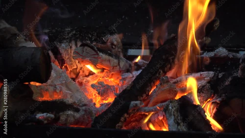 Bright fire flame from burning firewood from fruit trees on an open grill in the evening Bright fire flame from burning firewood from fruit trees on an open grill in the evening