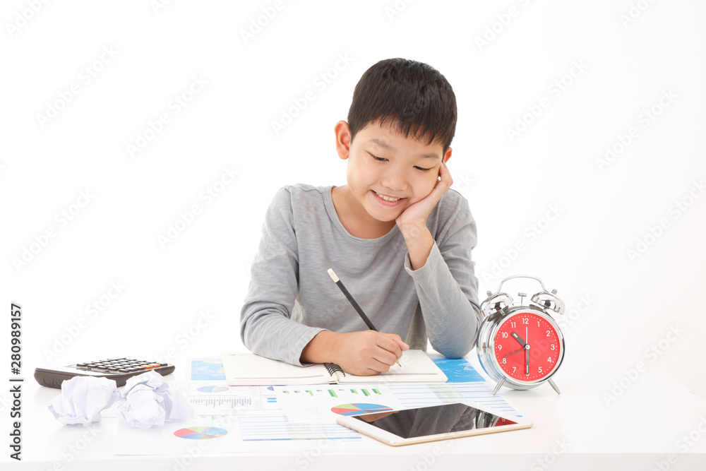 Little asian boy use pencil writing on notebook with smiling face on white background. Planing Education Concept. Little asian boy use pencil writing on notebook with smiling face on white background. Planing Education Concept.