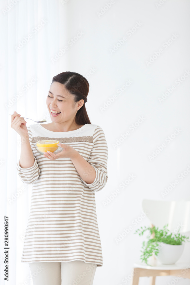 グレープフルーツを食べる女性