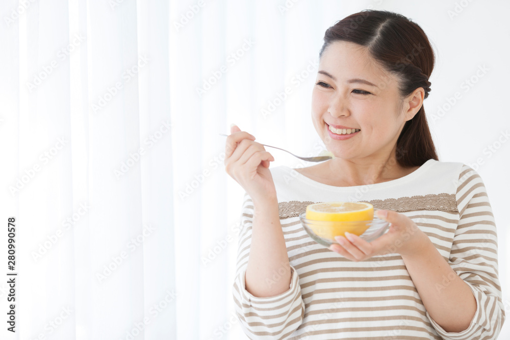 グレープフルーツを食べる女性