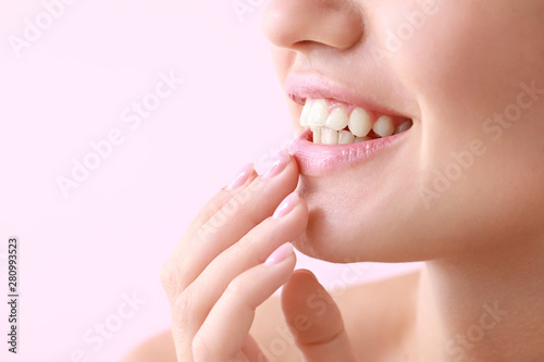 Young woman with beautiful lips on color background, closeup