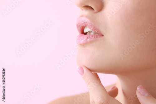 Young woman with beautiful lips on color background  closeup