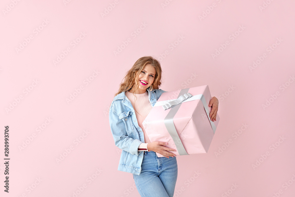 Happy young woman with gift box on color background Happy young woman with gift box on color background