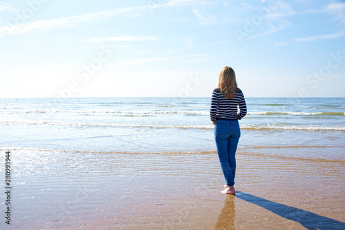 Rear view shot of woman standing on the beac