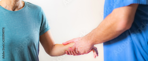  Therapist Checking Senior Woman’s Arm