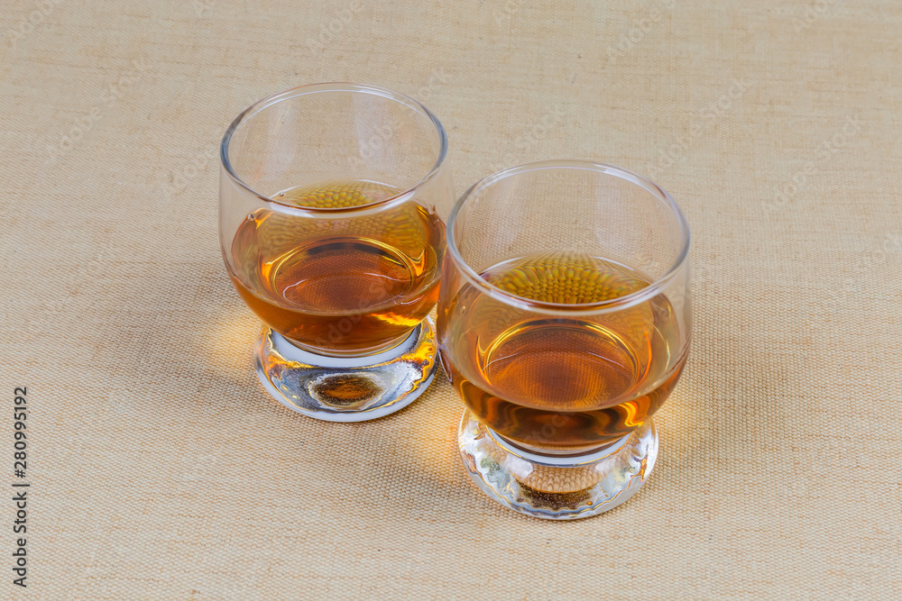 Two glasses of brandy on a textile surface Two glasses of brandy on a textile surface