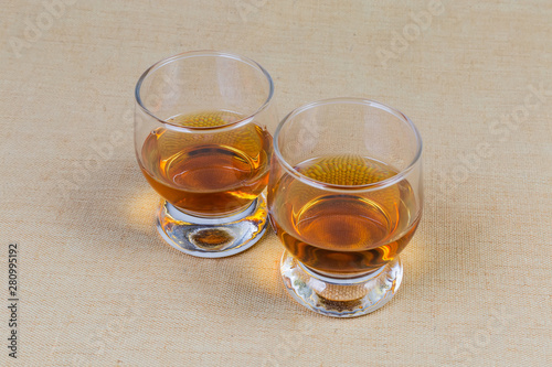 Two glasses of brandy on a textile surface